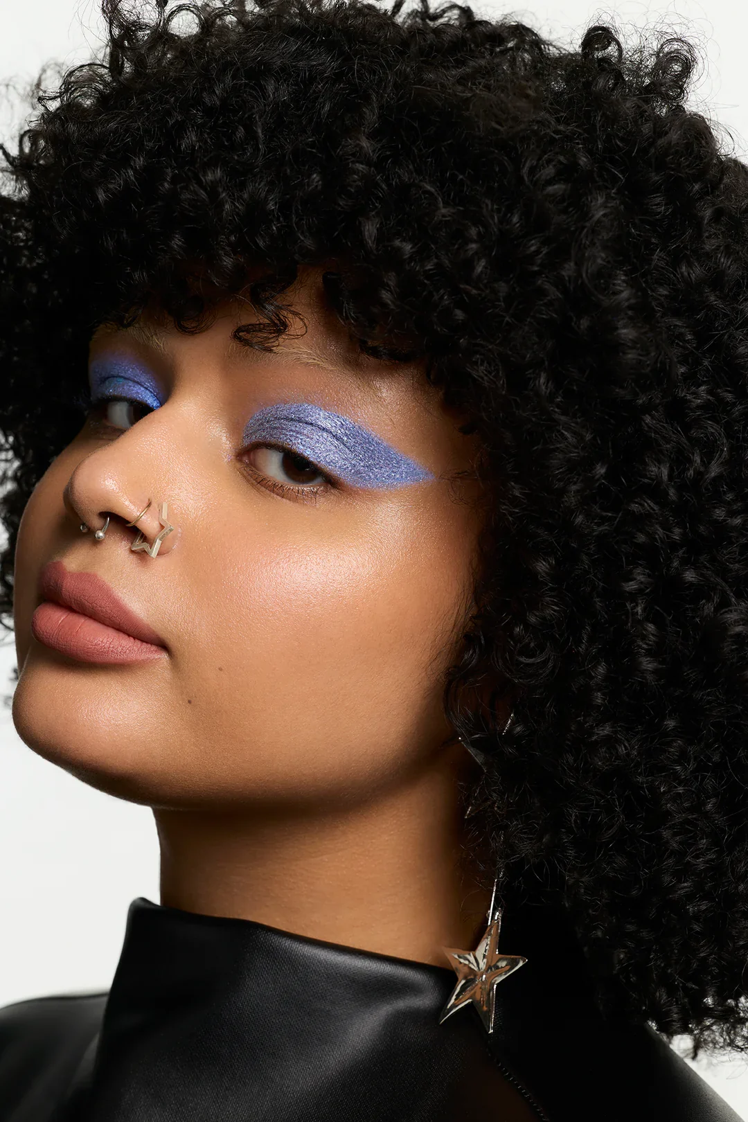 Close portrait with periwinkle graphic eyeshadow.